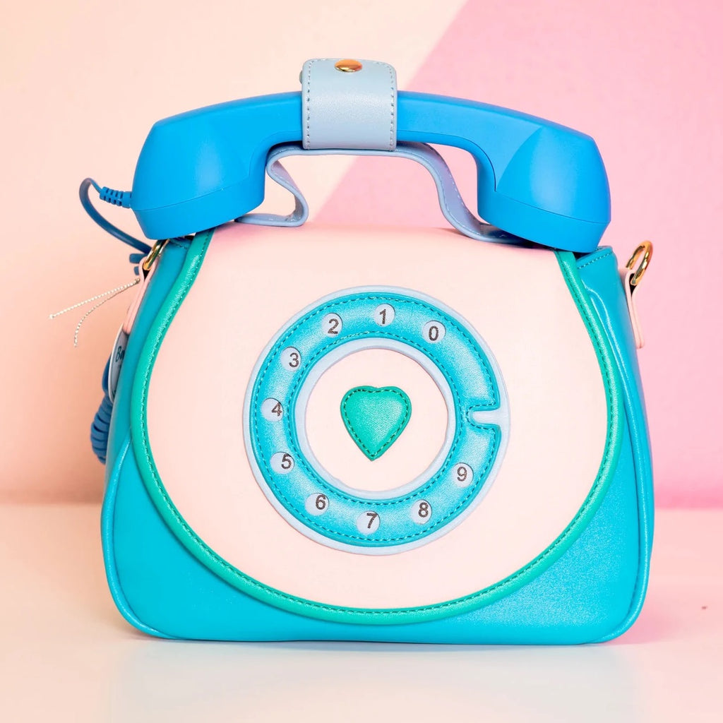 Novelty purse from Bewaltz that resembles a rotary phone, complete with a functioning blue phone handle and faux rotary dial on the front flap.