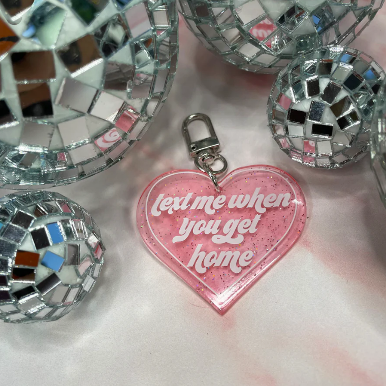 pink glitter heart keychain with the phrase "text me when you get home"